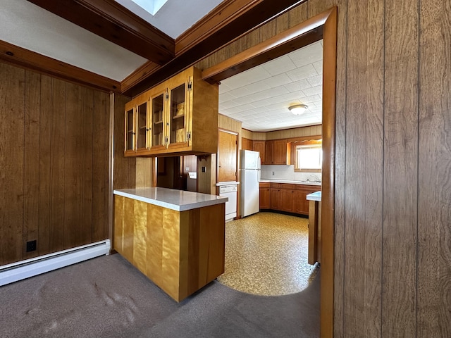 kitchen featuring kitchen peninsula, wood walls, white appliances, and a skylight