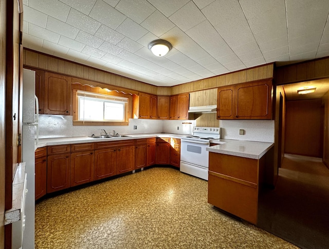 kitchen featuring sink, wooden walls, and white range with electric cooktop