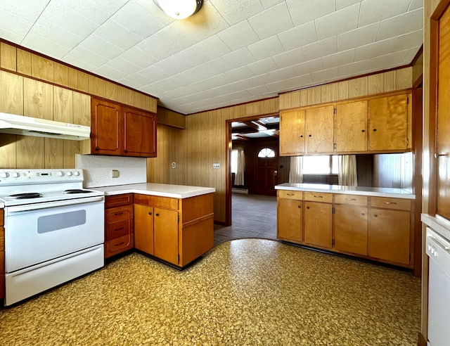 kitchen featuring wooden walls, white appliances, and kitchen peninsula