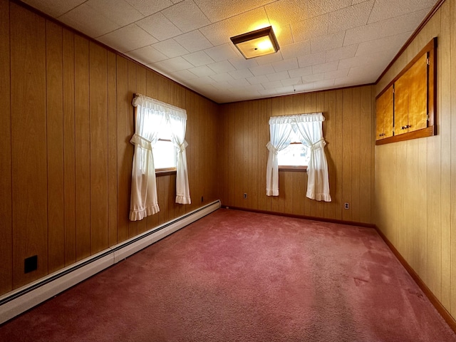 empty room with carpet floors, a baseboard radiator, and wood walls