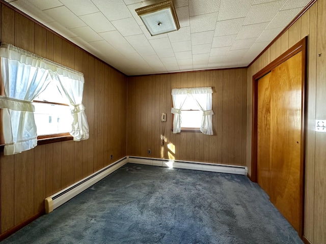 carpeted spare room featuring wood walls