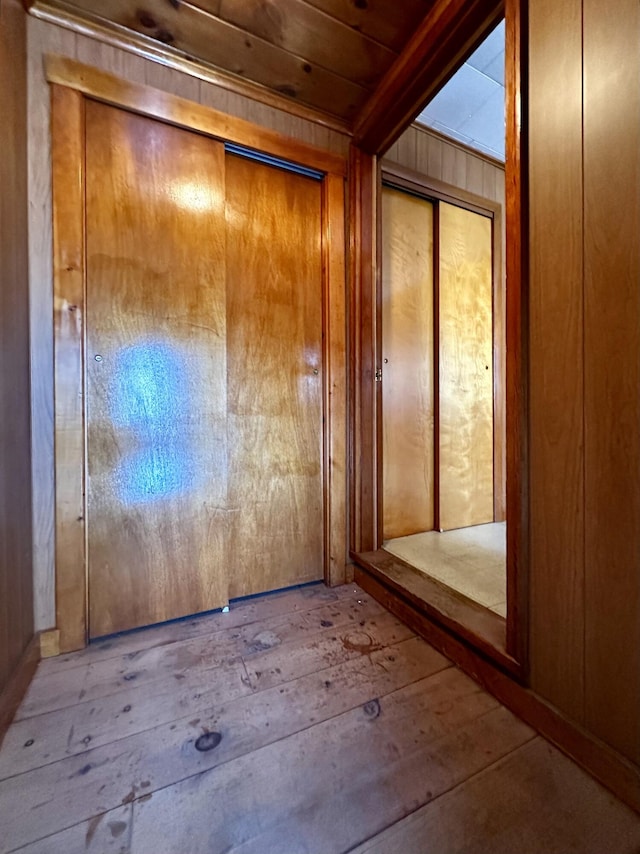 interior space featuring wooden ceiling, wooden walls, and light wood-type flooring