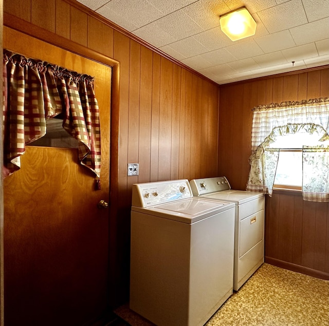 laundry room with washing machine and dryer and wooden walls