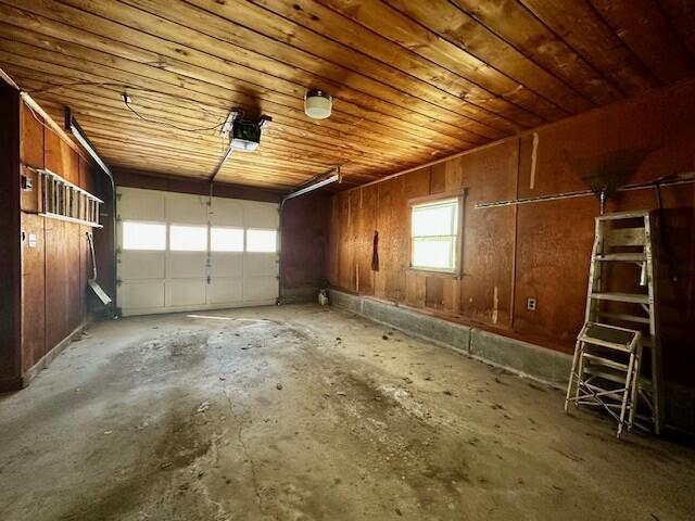 garage with a garage door opener and wooden ceiling