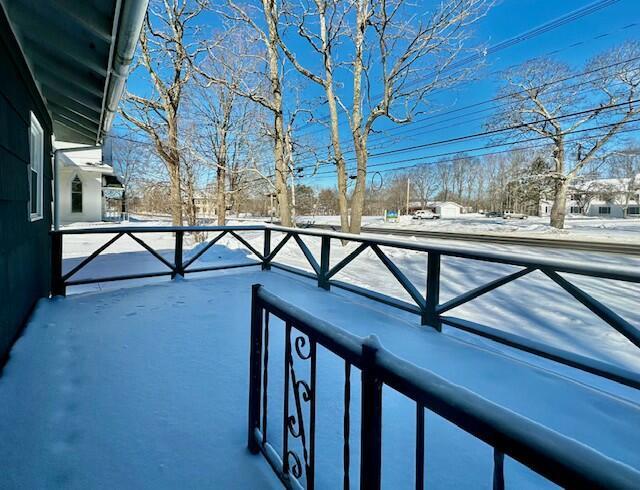 view of snow covered back of property