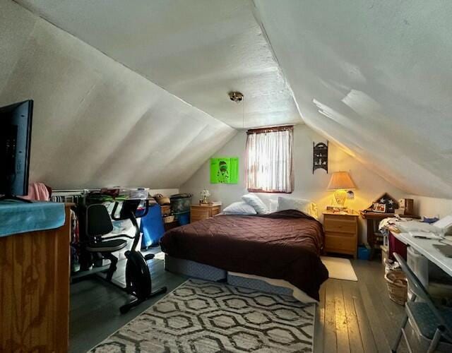 bedroom with hardwood / wood-style flooring and lofted ceiling