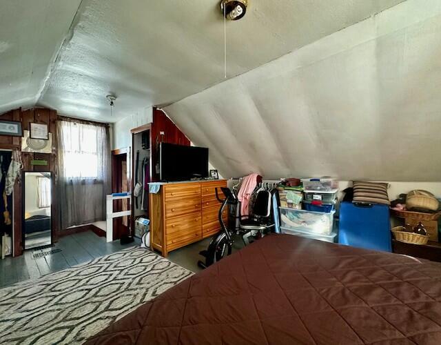 bedroom with lofted ceiling and dark hardwood / wood-style floors