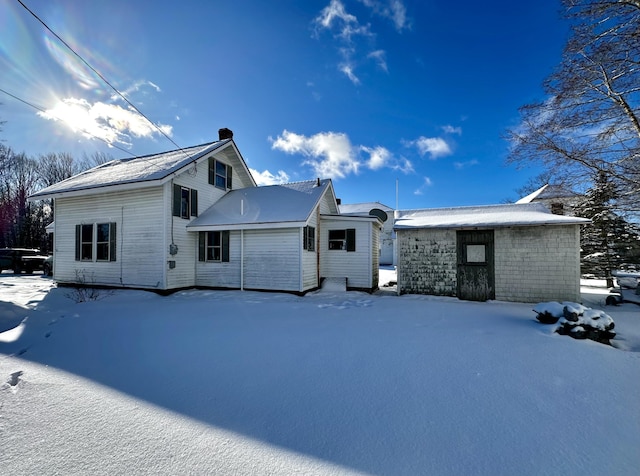 view of snow covered rear of property