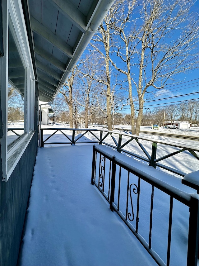 view of snow covered back of property