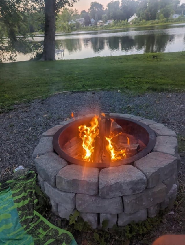 view of yard featuring a water view and an outdoor fire pit