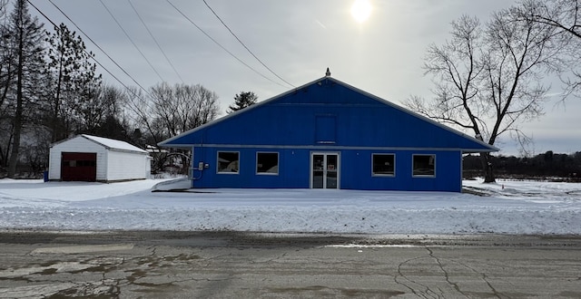 exterior space with a garage and an outbuilding