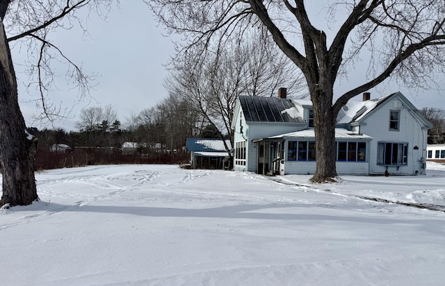 snowy yard with a sunroom