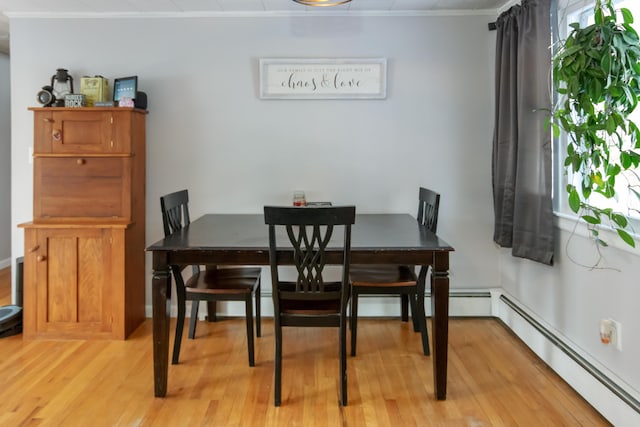 dining space featuring crown molding, light wood-type flooring, and a baseboard radiator