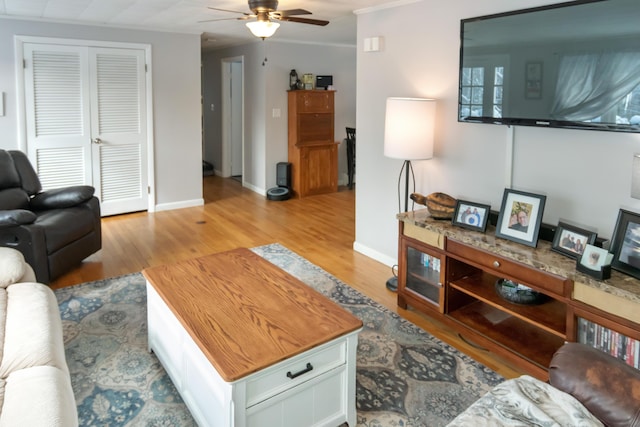 living room featuring crown molding, ceiling fan, and light hardwood / wood-style floors