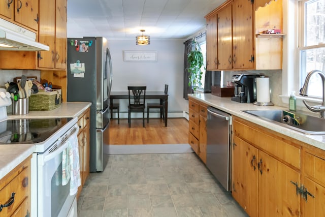 kitchen with stainless steel appliances, a baseboard heating unit, sink, and decorative backsplash