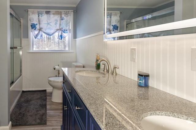 full bathroom featuring enclosed tub / shower combo, vanity, hardwood / wood-style floors, and toilet