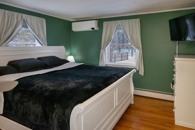 bedroom with hardwood / wood-style floors, crown molding, an AC wall unit, and baseboard heating