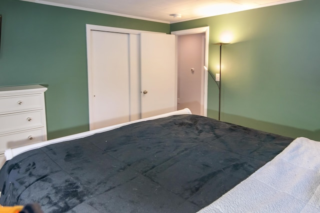 unfurnished bedroom featuring crown molding and a closet