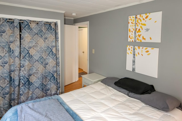 bedroom with hardwood / wood-style floors and crown molding