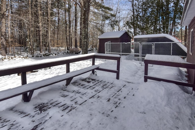 snow covered deck featuring a storage shed