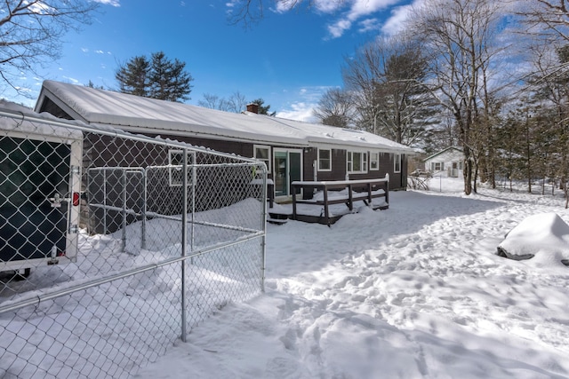 view of snow covered back of property