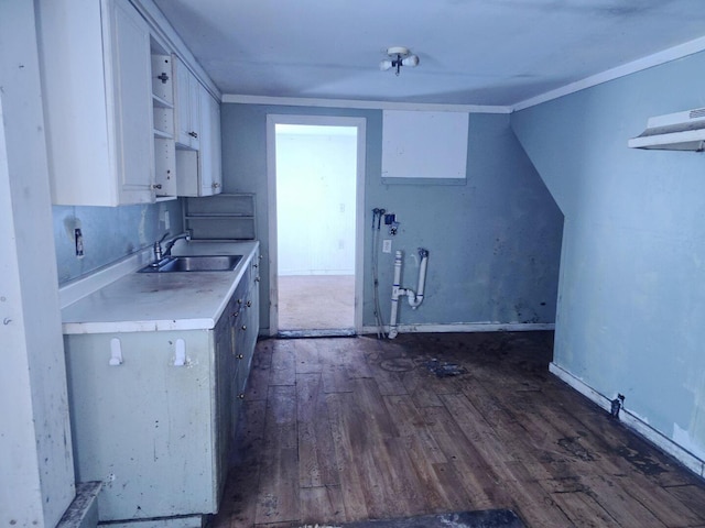 kitchen with crown molding, dark hardwood / wood-style flooring, sink, and white cabinets