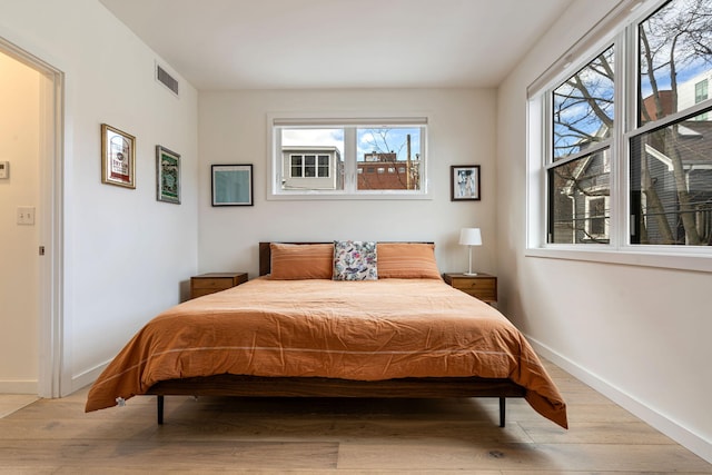 bedroom featuring baseboards, visible vents, and light wood-style floors