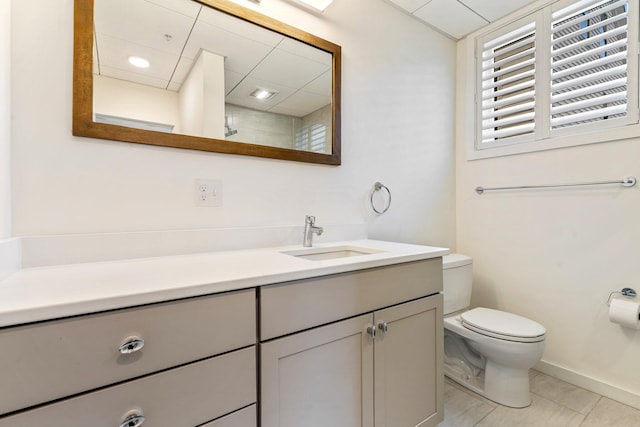 bathroom with baseboards, vanity, and toilet