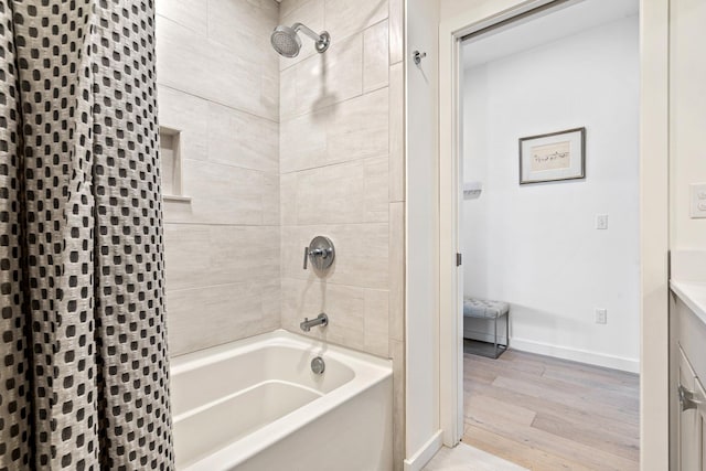 full bathroom featuring shower / bath combo with shower curtain, baseboards, and wood finished floors