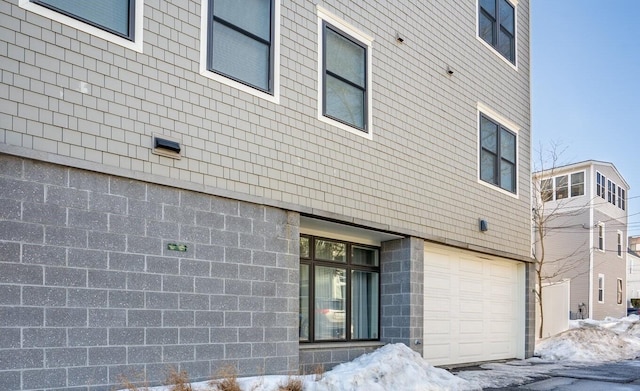 view of snow covered exterior featuring an attached garage