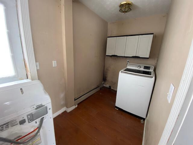 clothes washing area featuring dark wood-type flooring, cabinets, and baseboard heating