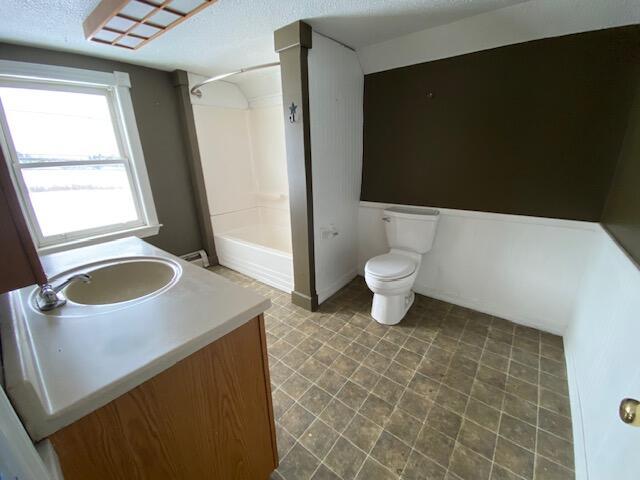 full bathroom with vanity, toilet, shower / bath combination, and a baseboard heating unit