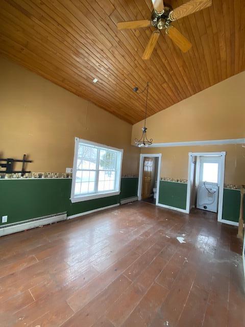 interior space featuring baseboard heating, a healthy amount of sunlight, high vaulted ceiling, and hardwood / wood-style flooring