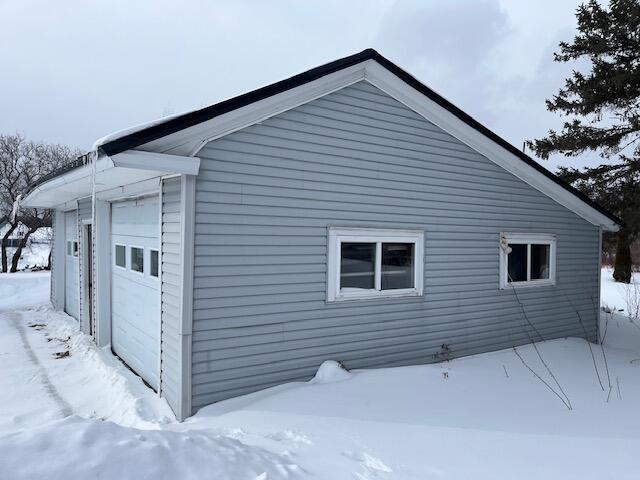 view of snowy exterior featuring a garage