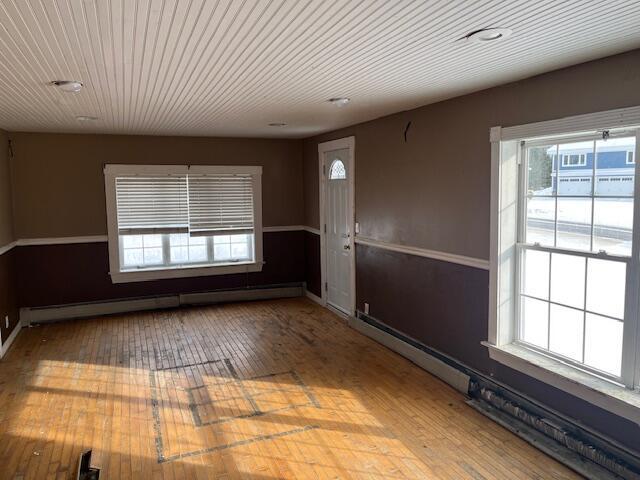 interior space featuring wood ceiling, hardwood / wood-style floors, and a baseboard heating unit