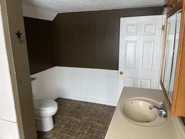 bathroom with vanity, a textured ceiling, and toilet