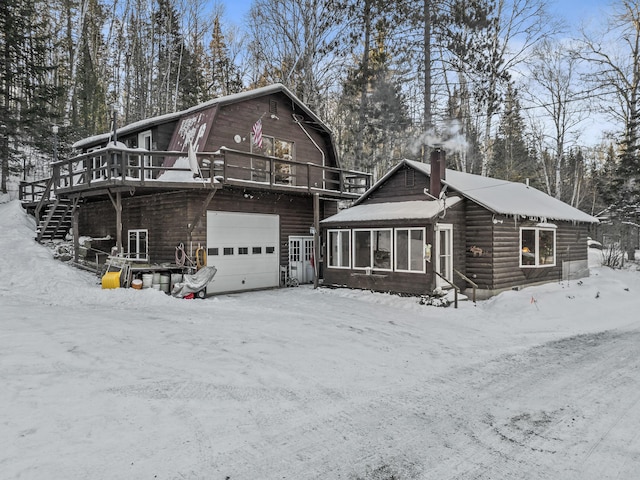 view of front of house featuring a wooden deck, a garage, and a sunroom