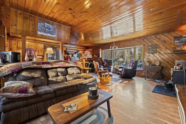 living room with wood ceiling, wood walls, and light wood-type flooring