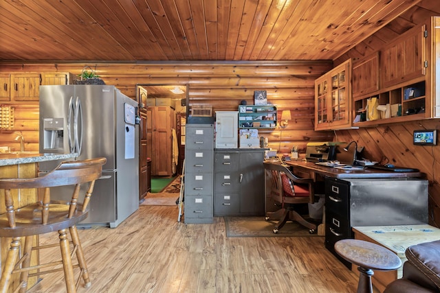 home office featuring log walls, sink, light hardwood / wood-style flooring, and wooden ceiling