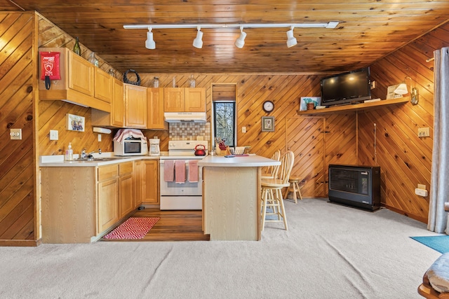 kitchen with wooden walls, sink, a breakfast bar area, light colored carpet, and white appliances