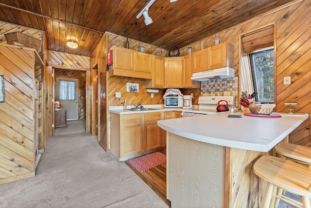 kitchen featuring sink, wood ceiling, a breakfast bar area, white electric stove, and wood walls