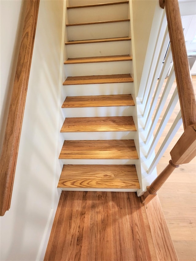 stairs featuring hardwood / wood-style floors