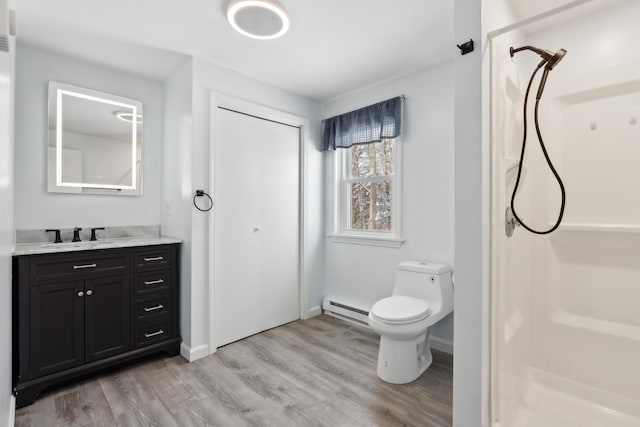 bathroom featuring baseboard heating, vanity, toilet, and hardwood / wood-style floors