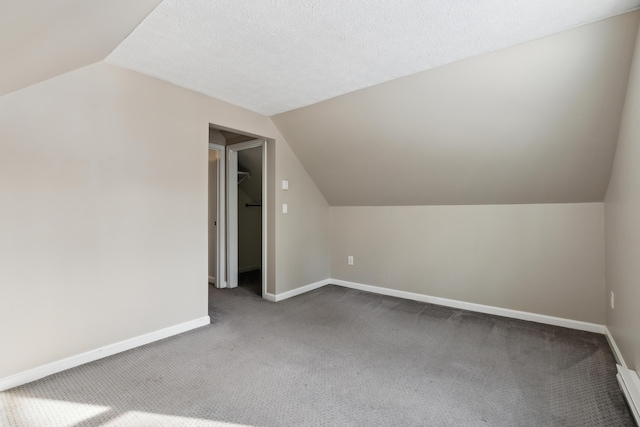 bonus room with carpet floors, vaulted ceiling, and a textured ceiling