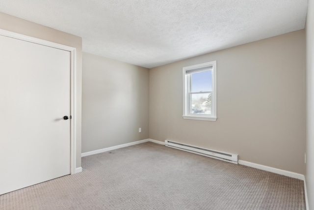 spare room with baseboard heating, light carpet, and a textured ceiling