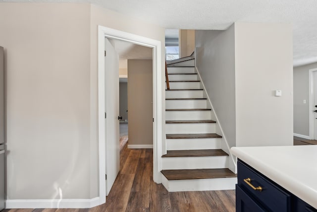 stairs featuring hardwood / wood-style floors and a textured ceiling