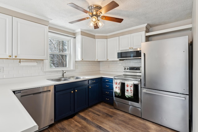 kitchen with sink, blue cabinetry, white cabinets, and appliances with stainless steel finishes