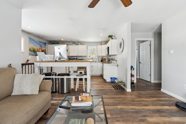 living room with dark wood-type flooring and ceiling fan