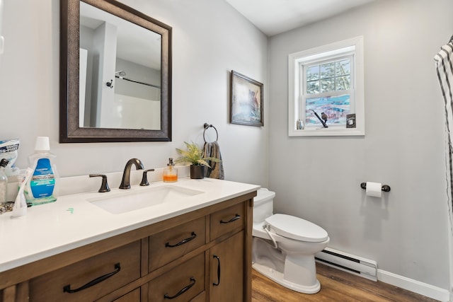 bathroom featuring toilet, a shower, vanity, hardwood / wood-style floors, and a baseboard heating unit