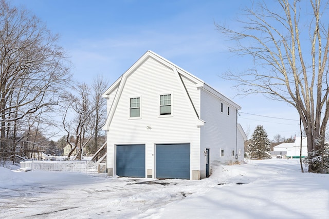 view of snowy exterior featuring a garage